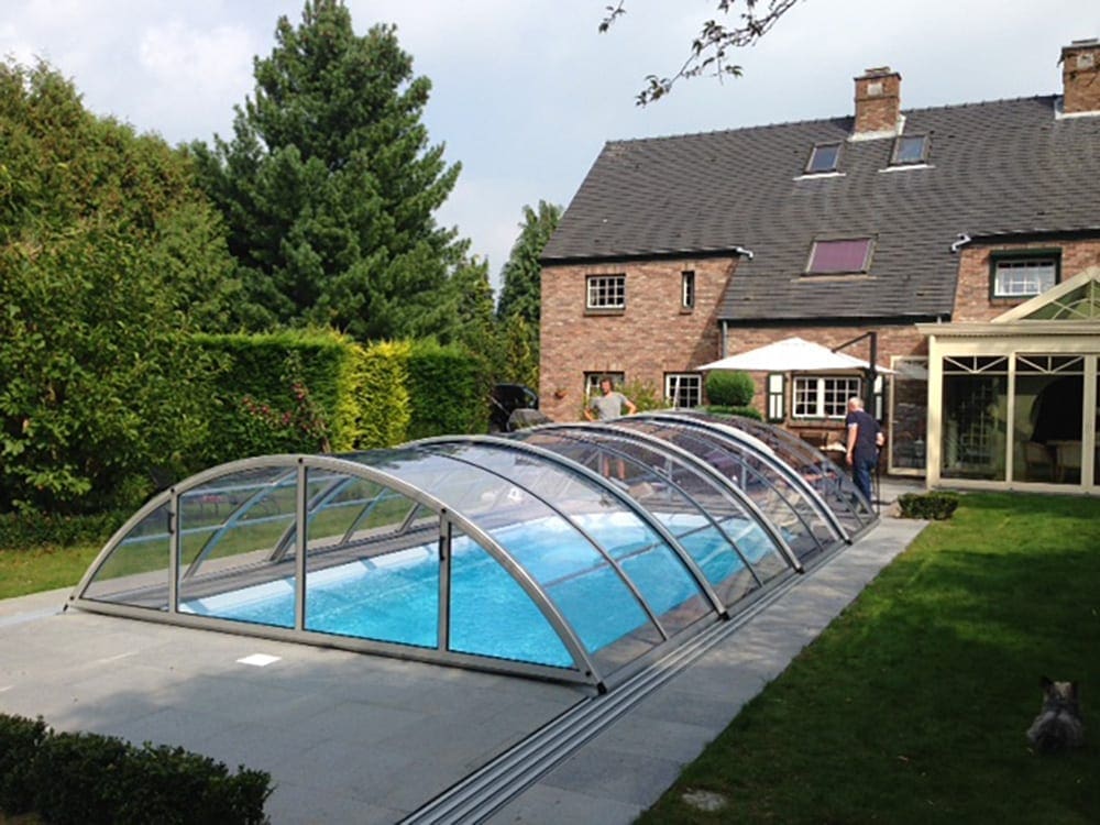 Curved Klasik A pool enclosure in a landscaped garden