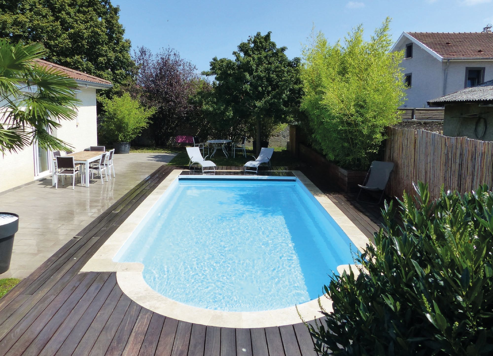Jupiter Evolutive fibreglass swimming pool in a landscaped garden