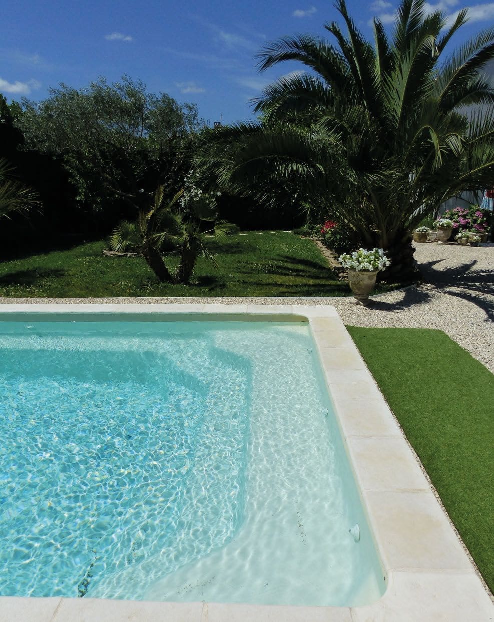 Oxilia curved fibreglass swimming pool in a landscaped garden