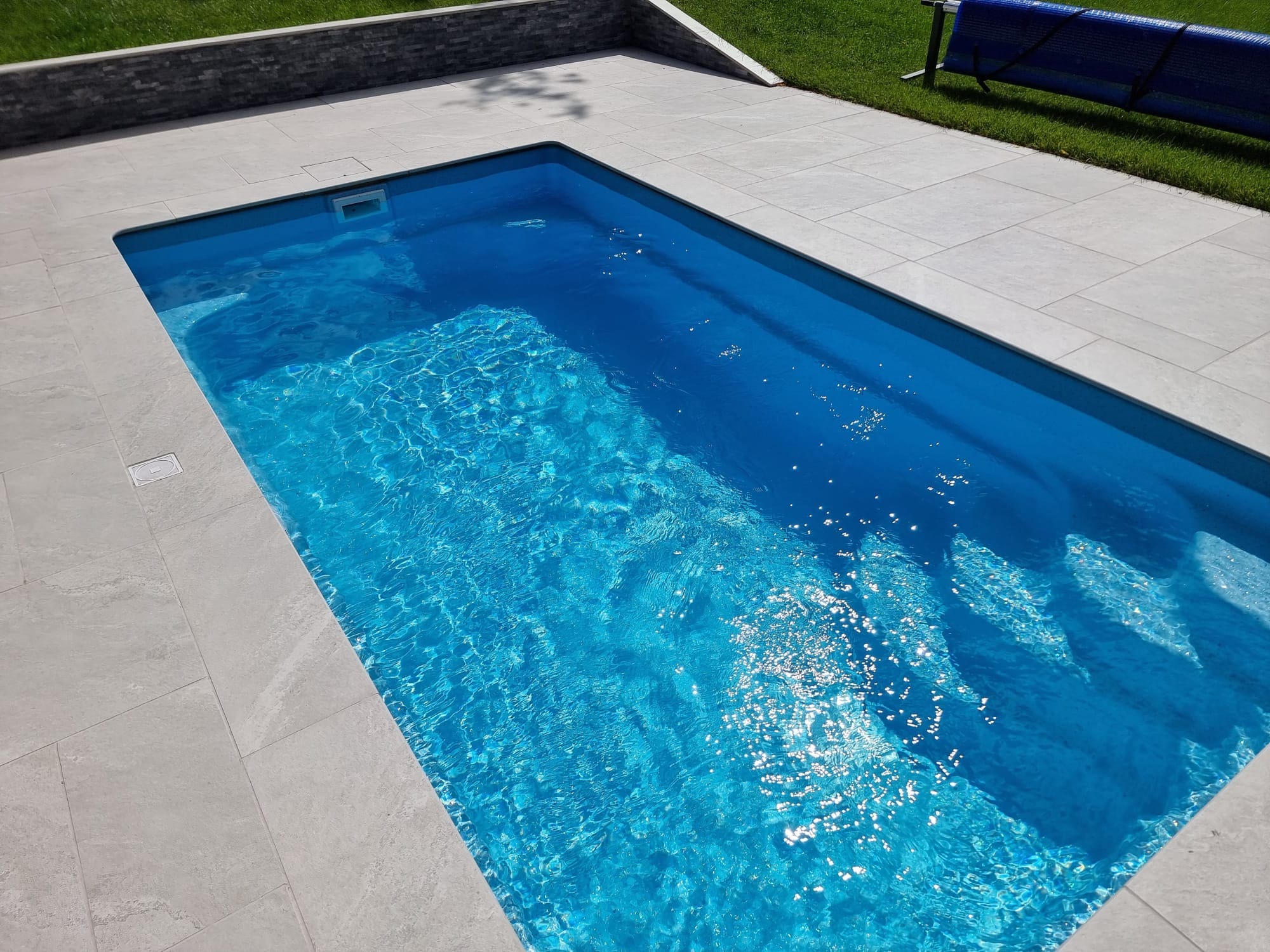 Completed swimming pool with sunlight reflecting on the water
